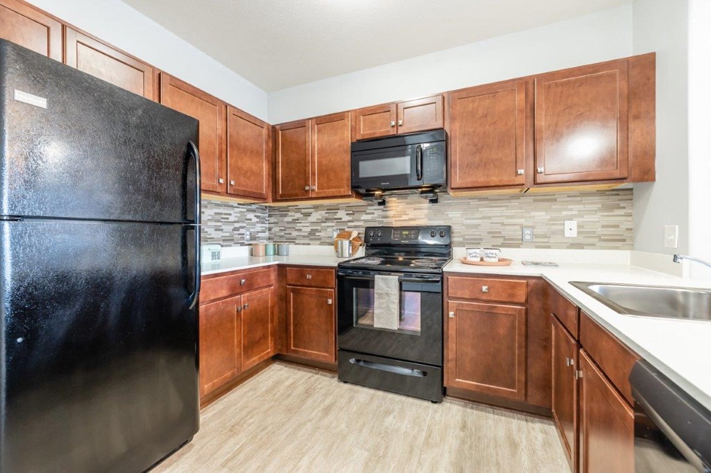 a kitchen with wooden cabinets and black appliances
