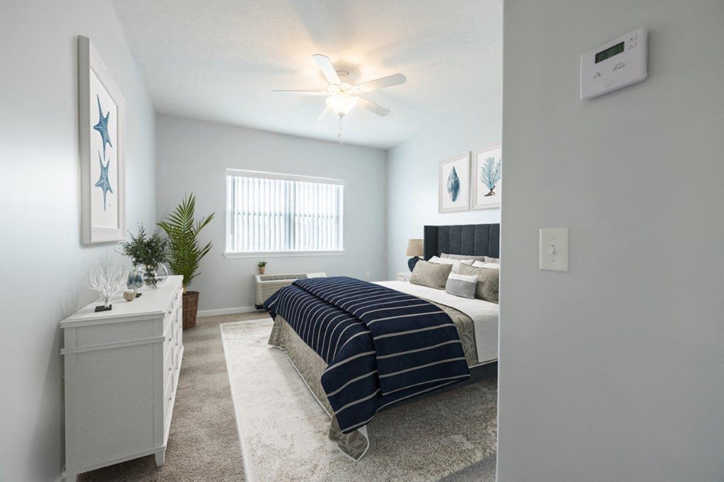 a bedroom with a bed and a ceiling fan