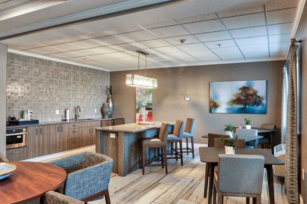 a lobby with a kitchen and tables and chairs