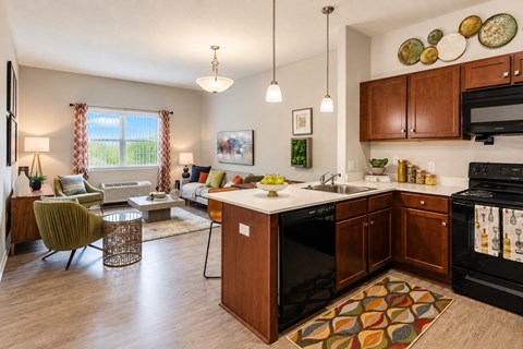 A kitchen with a black oven and wooden cabinets.