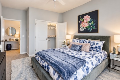 A bedroom with a large bed and a painting on the wall.