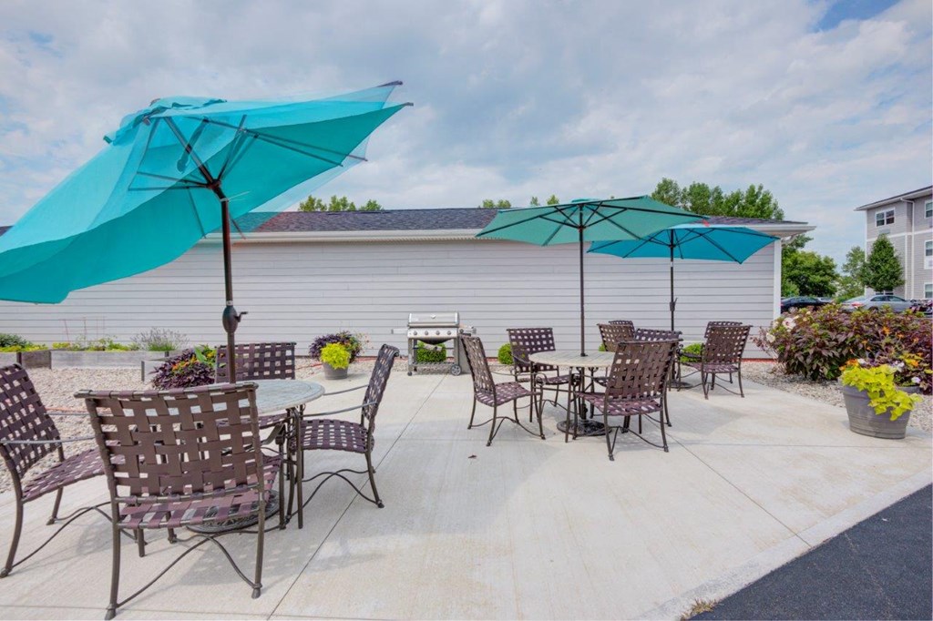a patio with tables and chairs and umbrellas