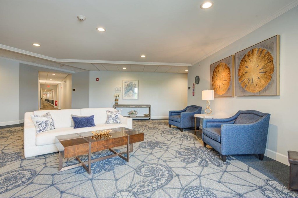 a living room with a white couch and two blue chairs