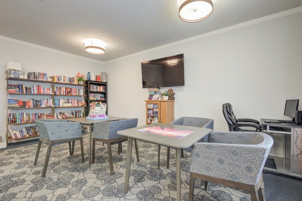 a living room with tables and chairs and a television