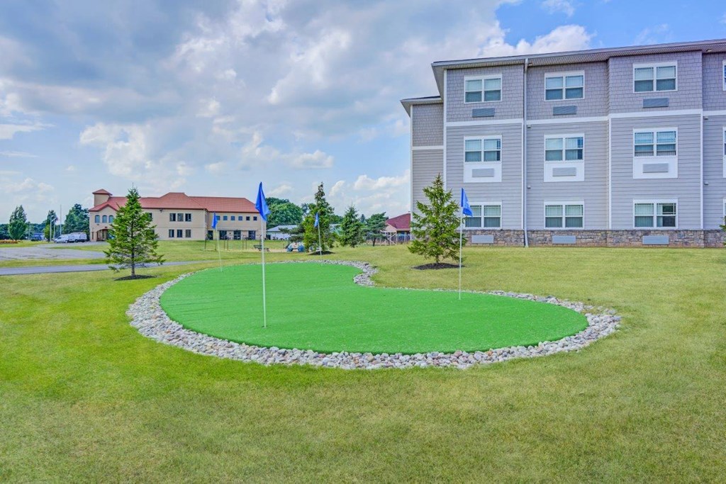 a round lawn with two flags in front of a building