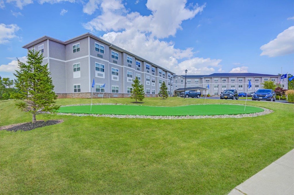 a green lawn in front of an apartment building