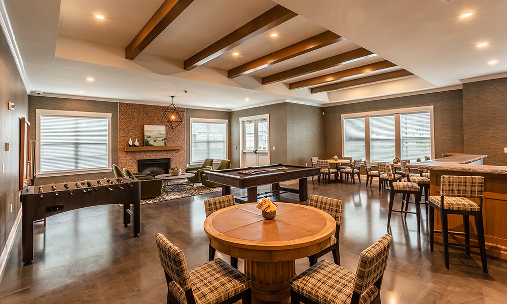 a game room with a pool table and tables