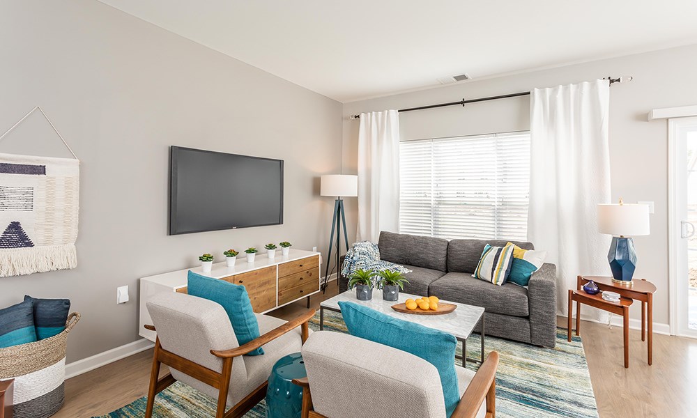 a living room with a couch and chairs and a tv