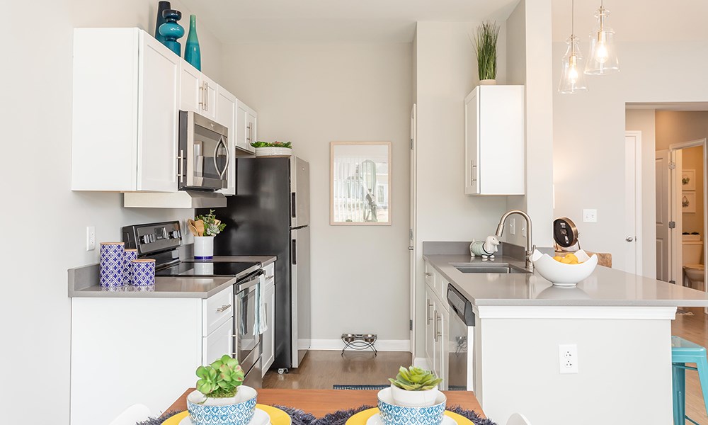 a renovated kitchen with white cabinets and stainless steel appliances