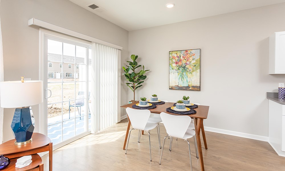 a dining room with a table and chairs and a sliding glass door