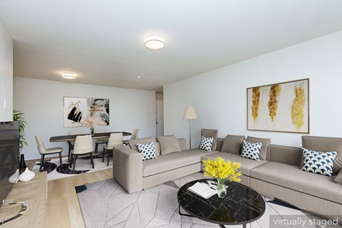 A living room with a grey couch and a coffee table with flowers on it.