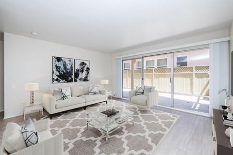 A living room with a white couch, a coffee table, and a painting on the wall.