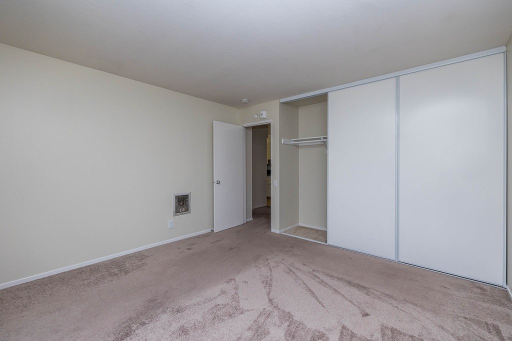 A room with a carpeted floor and a white door.