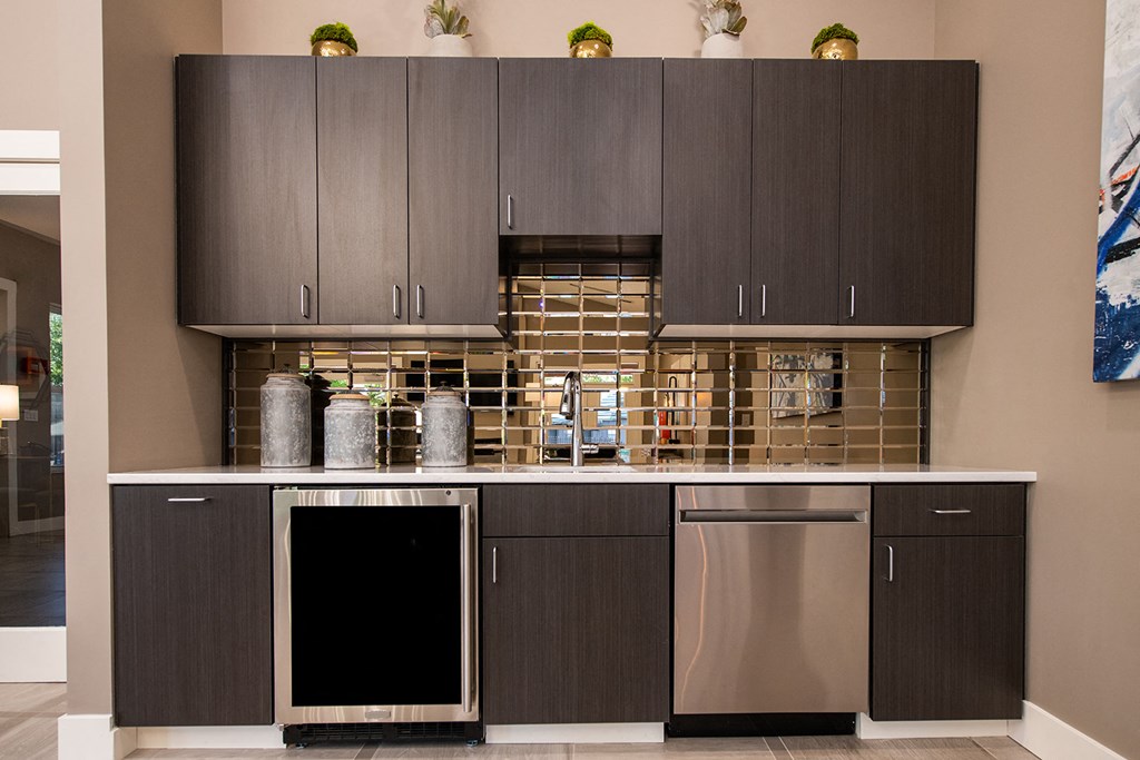 a kitchen with gray cabinets and stainless steel appliances