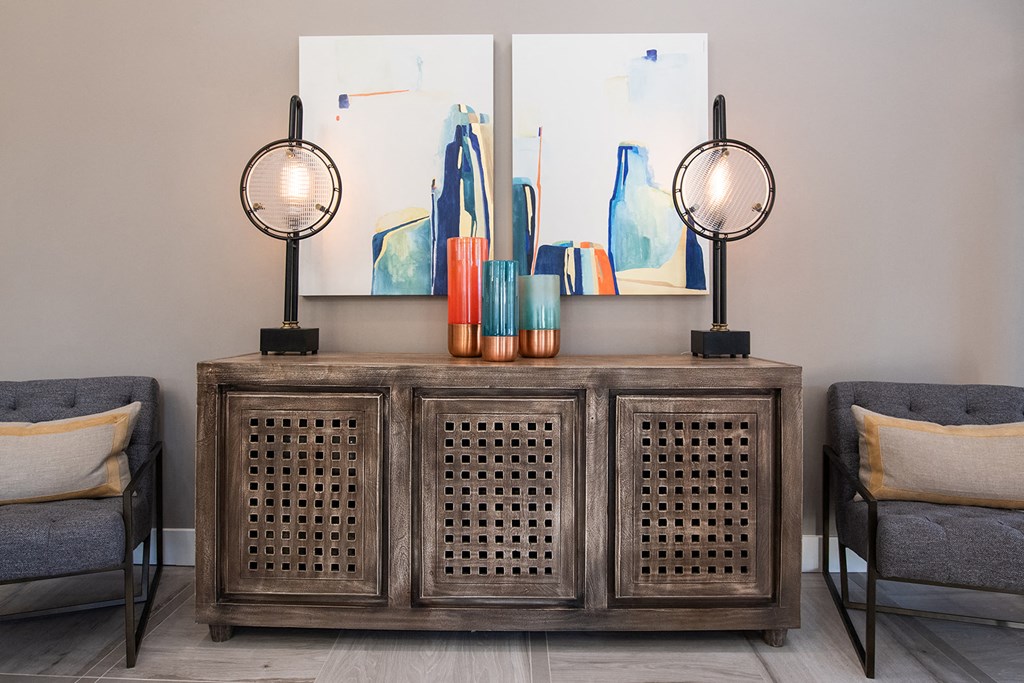 a room with a table and two chairs and two paintings on the wall