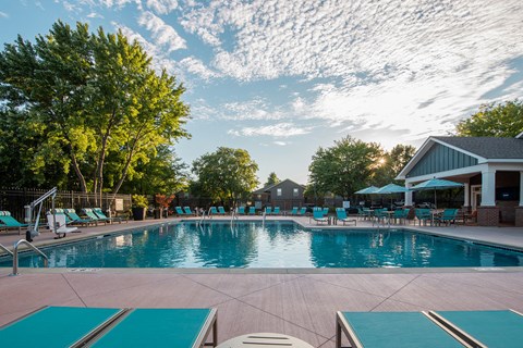 a swimming pool with lounge chairs and umbrellas