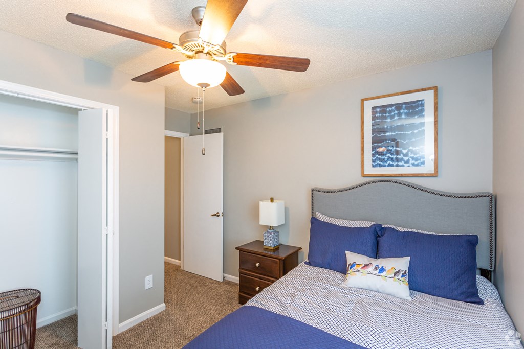a bedroom with a bed and a ceiling fan