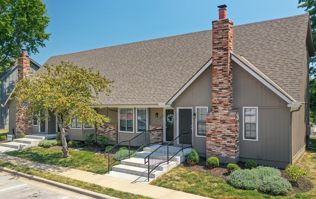 a house with a chimney and a tree in front of it