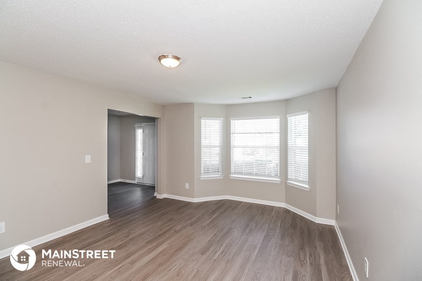 the spacious living room with wood flooring and large windows
