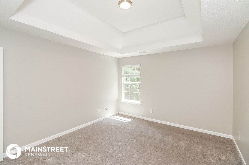 the spacious living room with a coffered ceiling and a window