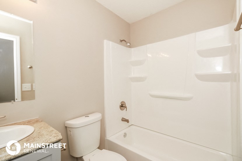 a bathroom with a shower and a toilet and a sink