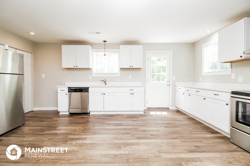 a white kitchen with white cabinets and stainless steel appliances