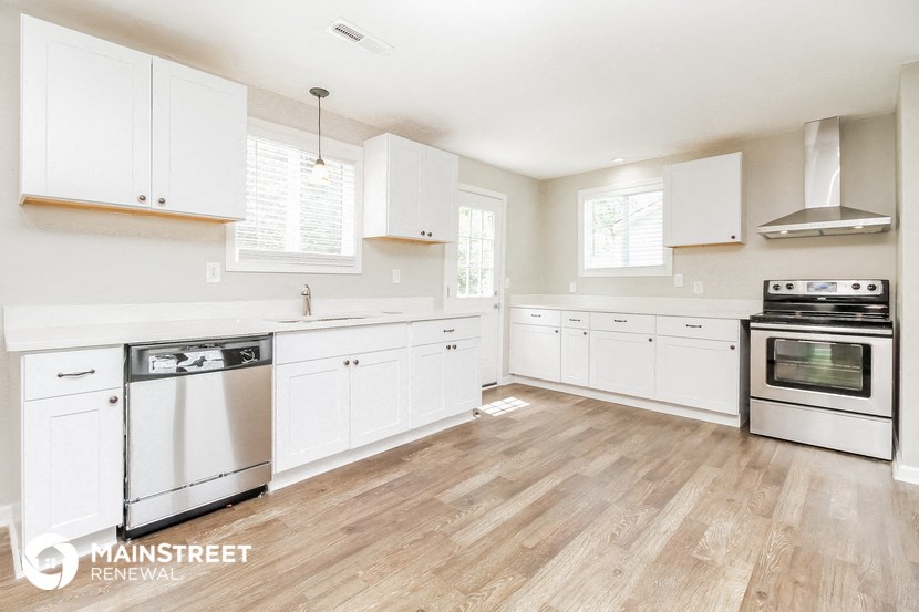 a white kitchen with white cabinets and stainless steel appliances