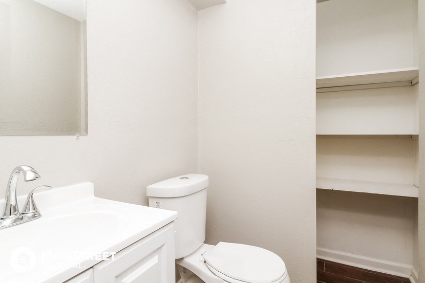 a bathroom with a sink toilet and a mirror