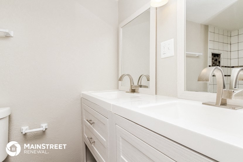a white bathroom with a sink and a mirror