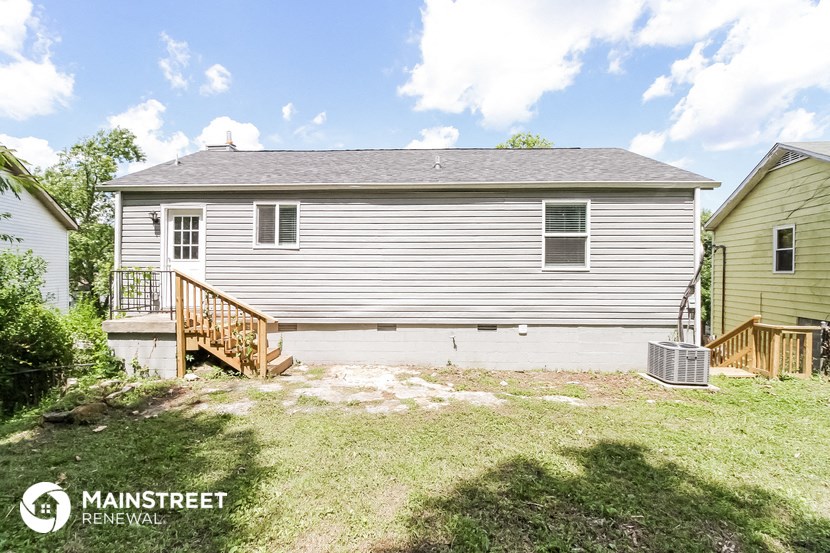 a backyard with a white house and a garage