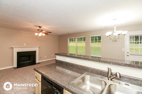 the kitchen has granite counter tops and stainless steel appliances and a fireplace