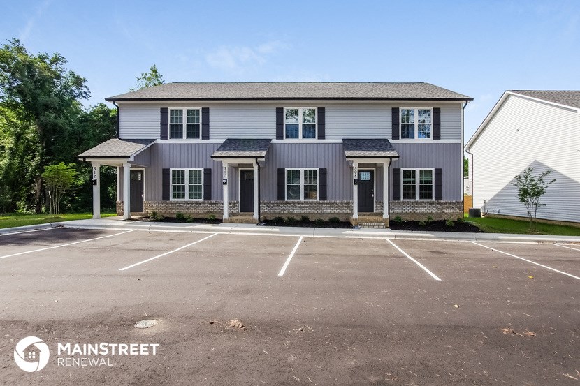 an empty parking lot in front of a house