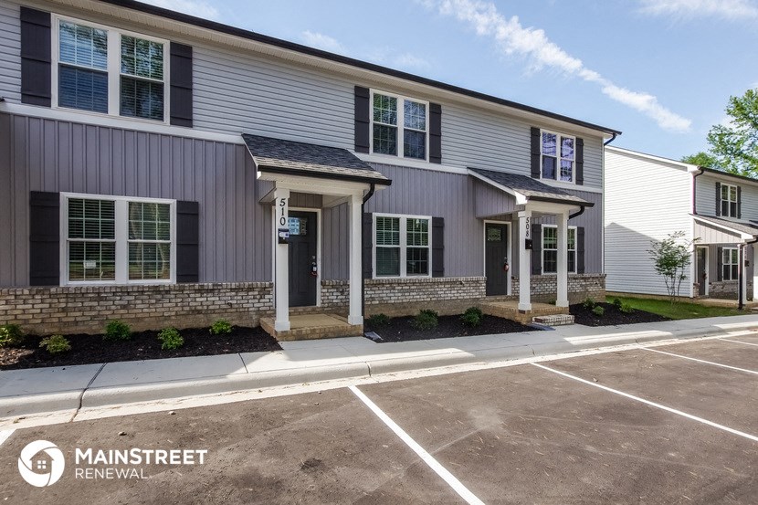 an exterior view of an apartment building with a parking lot