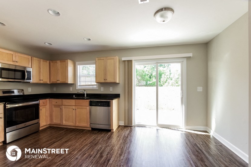 an empty kitchen with wooden cabinets and a sliding glass door