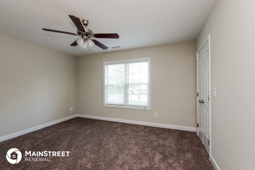the master bedroom has a ceiling fan and carpeted flooring