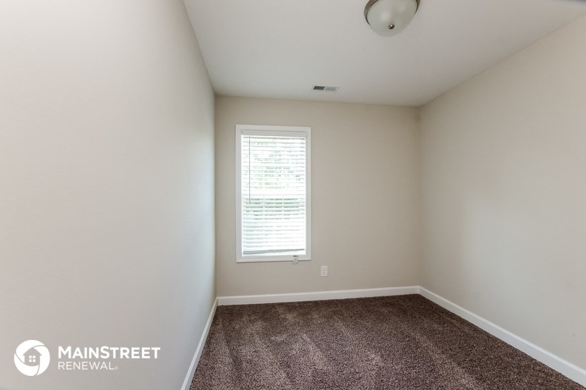 an empty room with carpet and a window