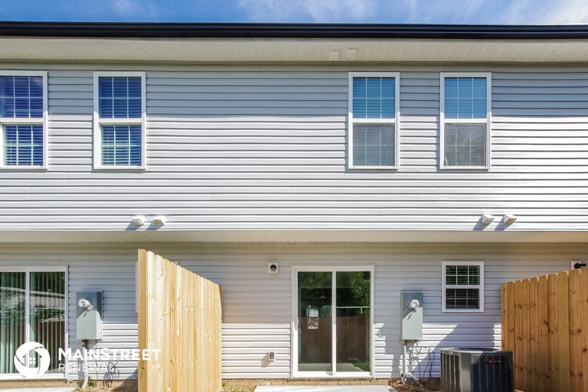 a white house with a wooden fence in front of it