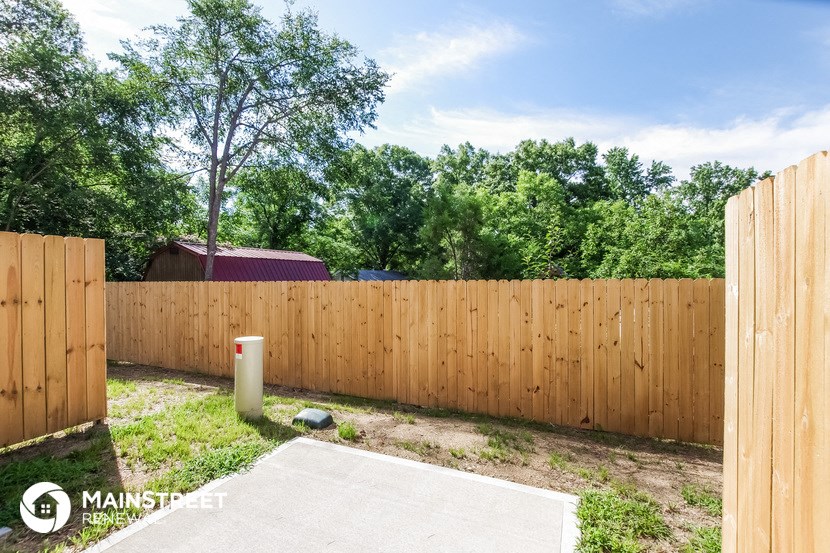 a wooden fence in a backyard with trees