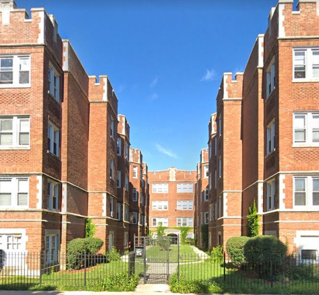 a row of red brick apartment buildings on a city street