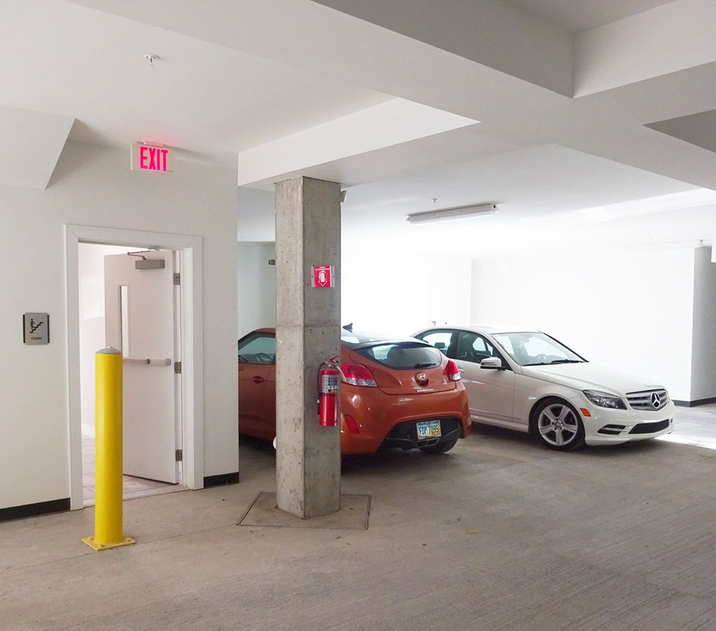 two cars parked in a parking garage with an exit door