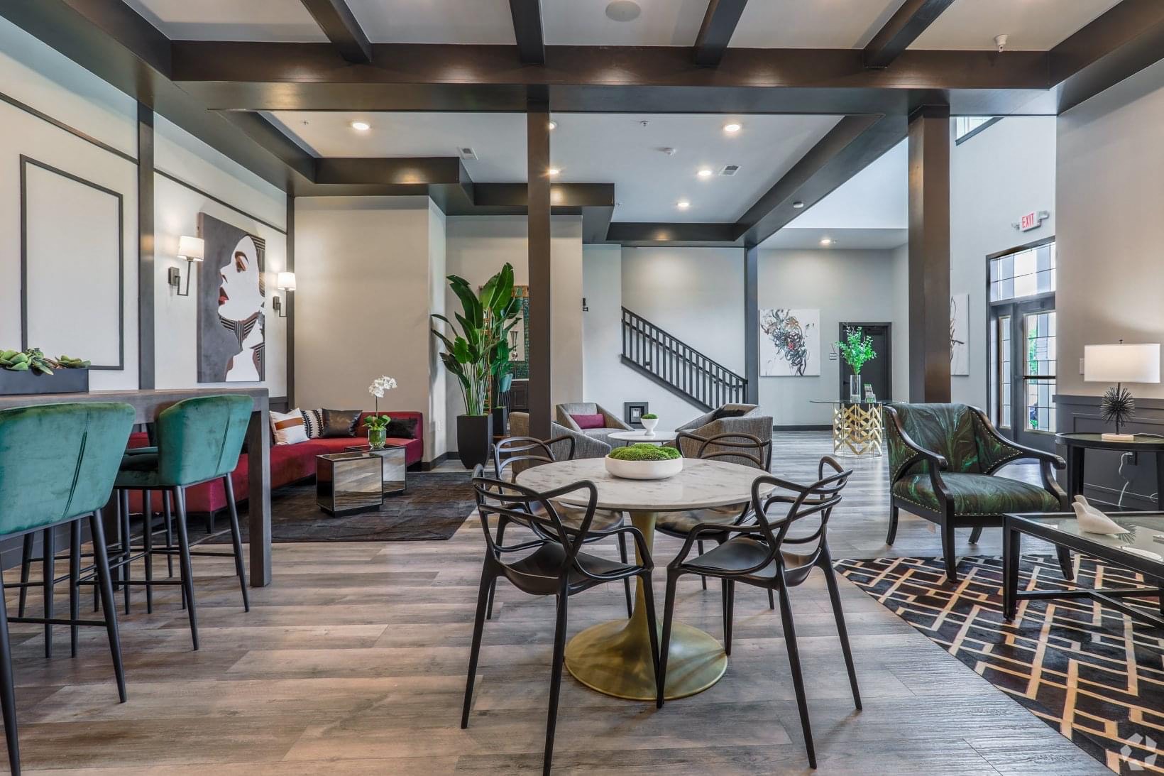a living room with tables and chairs and a staircase