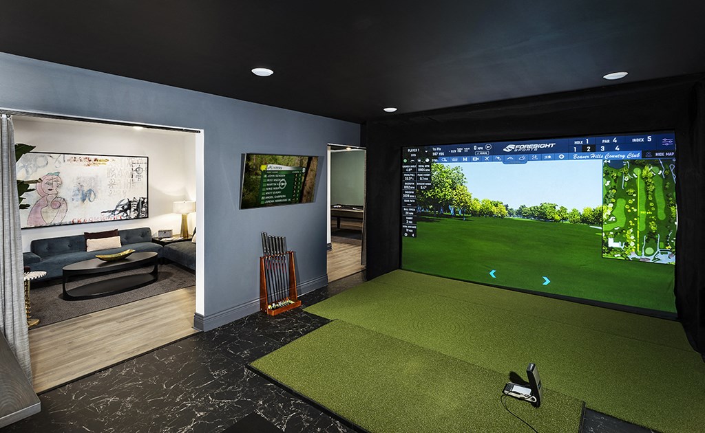 a golf simulator in a house with a view of the golf course on the screen