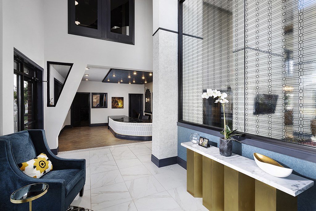 a living room with a blue couch and a tub and a large window