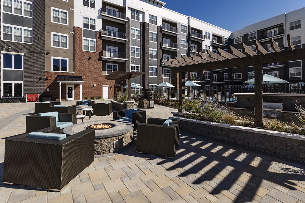 an outdoor patio with a fire pit at an apartment complex