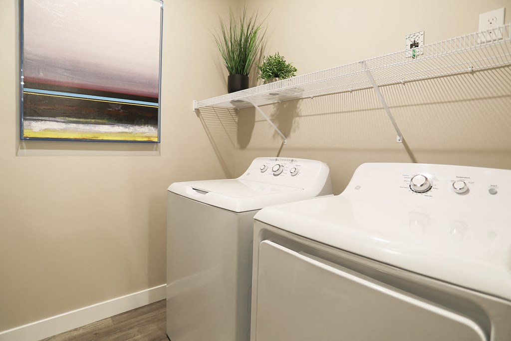 a washer and dryer in a laundry room with a painting
