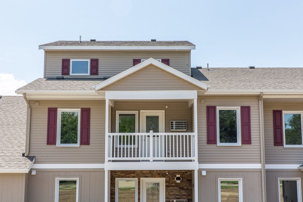 a large house with purple window shutters and a porch