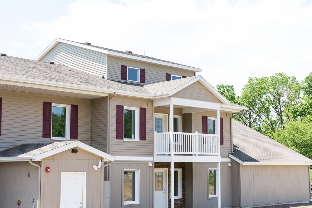 the exterior of a house with a porch and a balcony