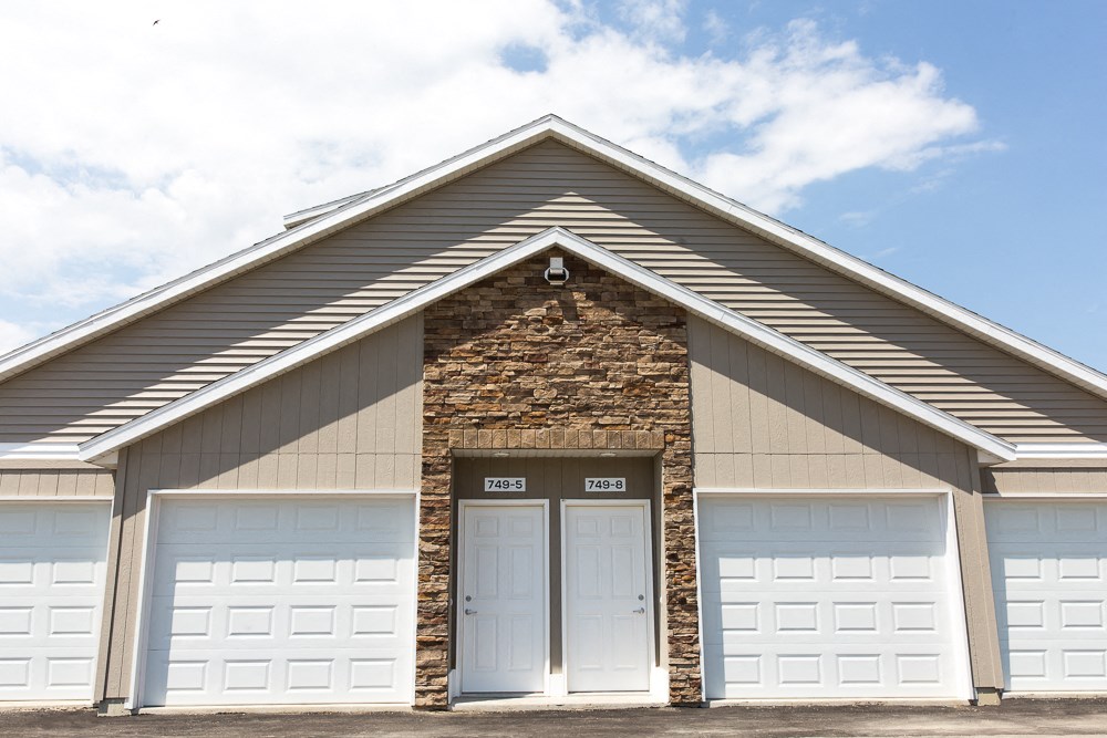 the front of a building with two white garage doors