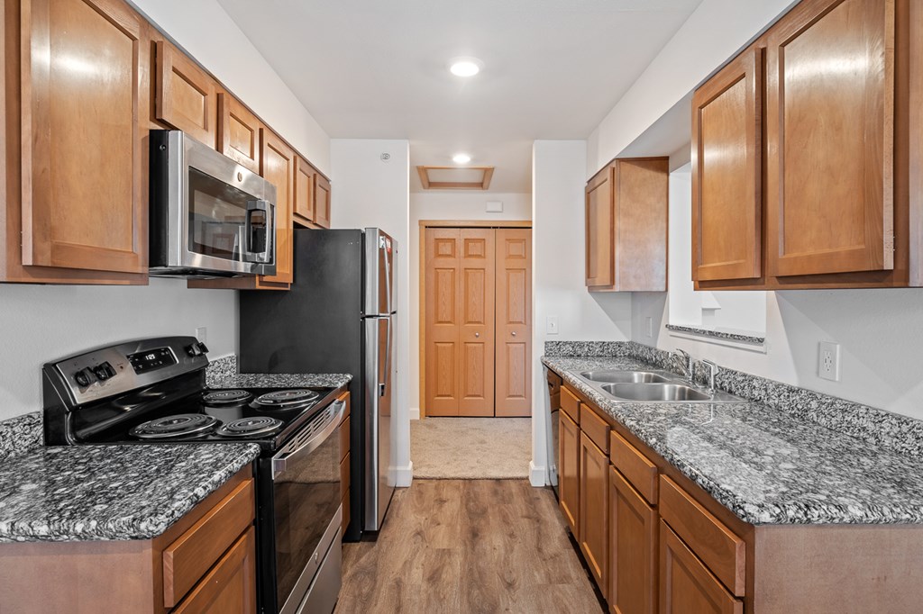 A kitchen with wooden cabinets and granite countertops.