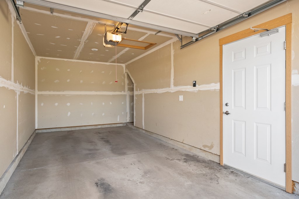 A room with a white door and a ceiling with lights.